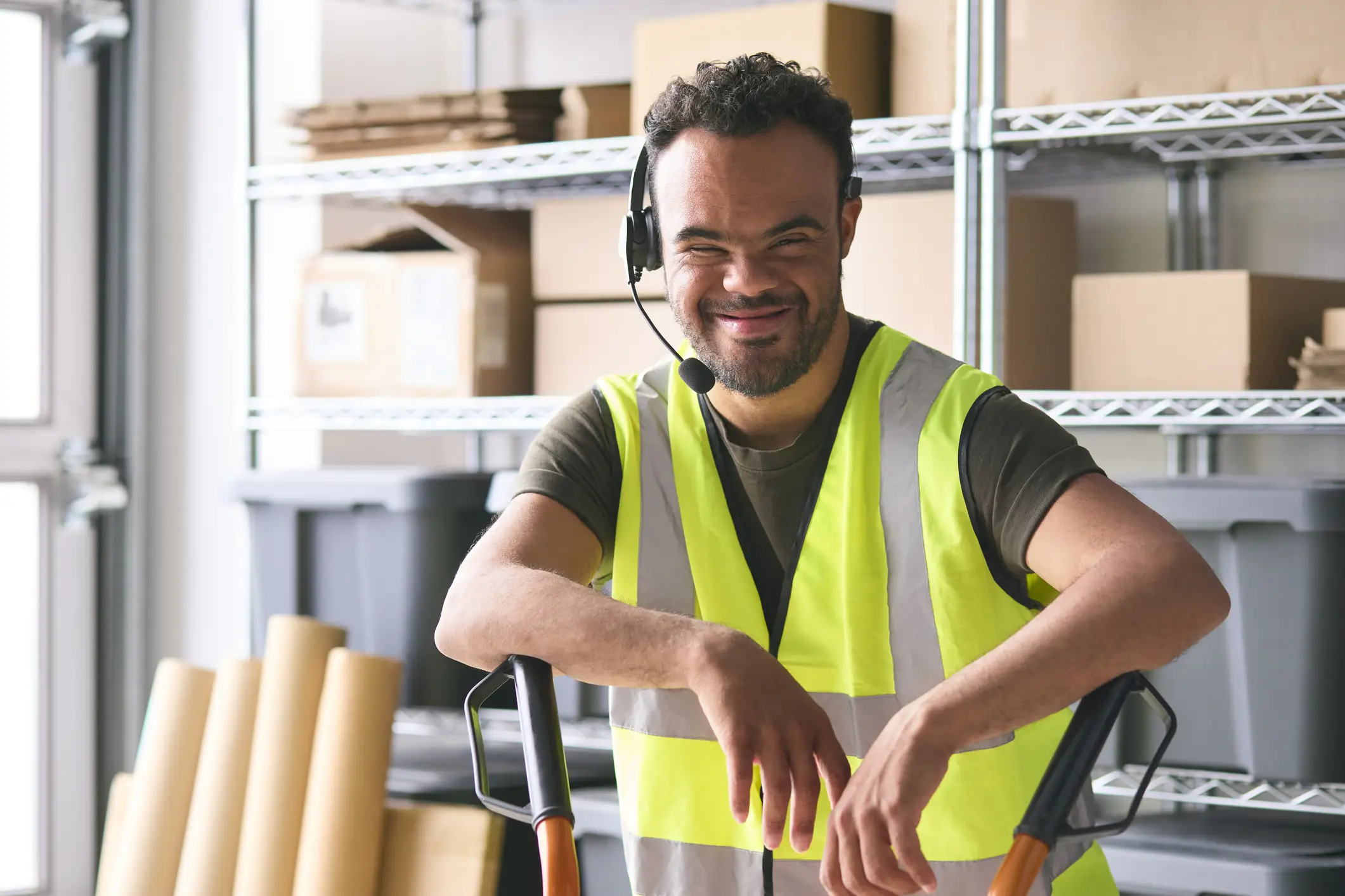 A man wearing a yellow vest and headphones.