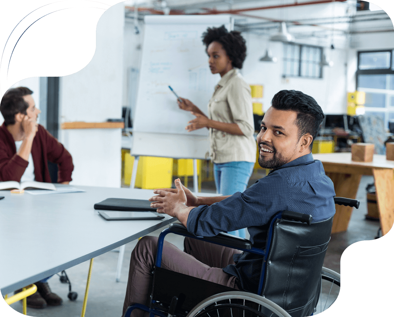 A man in a wheelchair at a table with other people.